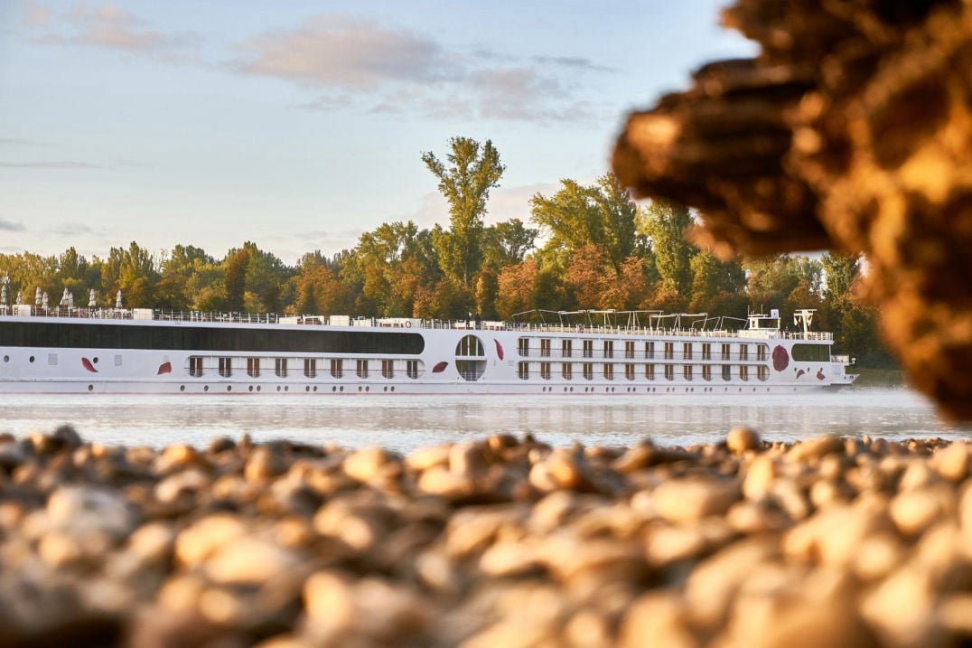 Ein modernes Kreuzfahrt-Schiff fährt in ruhigem Fahrwasser: Stressfreie Erholung. 