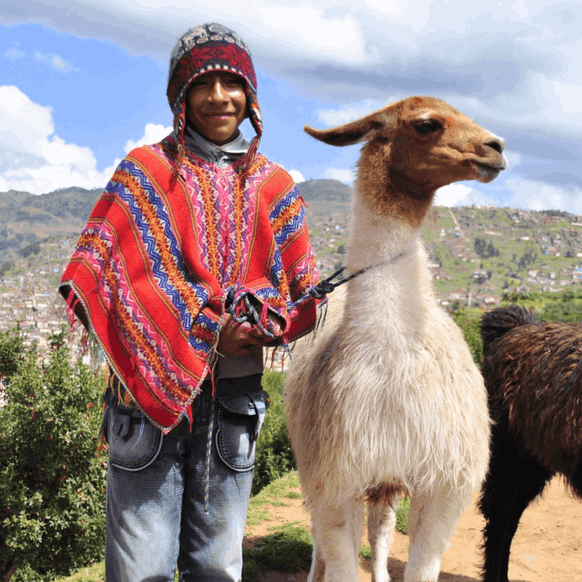 Ein Hirtenjunge in Peru mit einer Ziege.