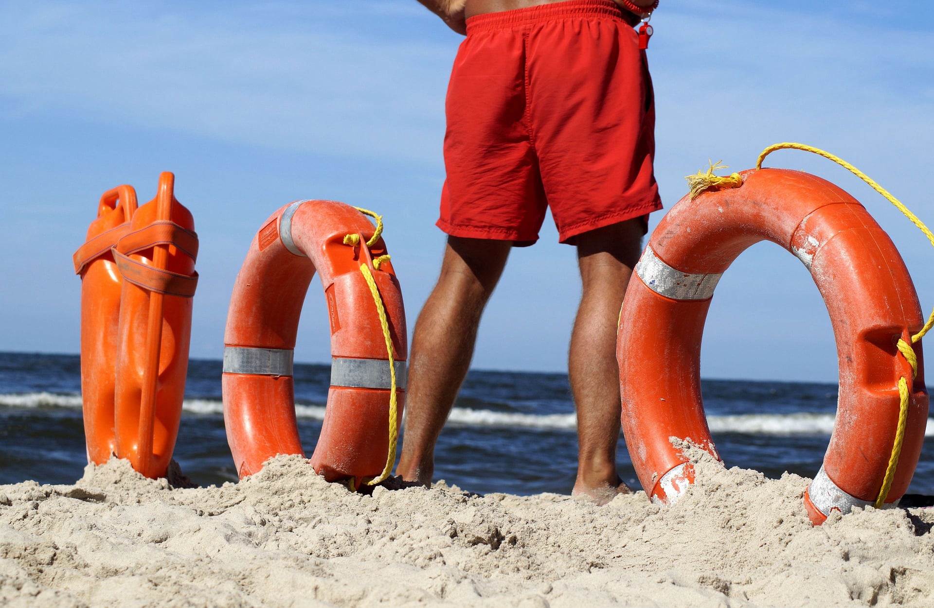 Ein Lebensretter zwischen Rettungsringen am Strand: Sicherheit auf Reisen. 
