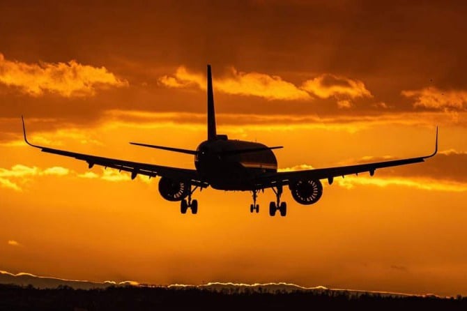 Rückenansicht eines landenden Flugzeugs im Sonnenlicht: Eine Symbiose aus Balance und Ausgeglichenheit.